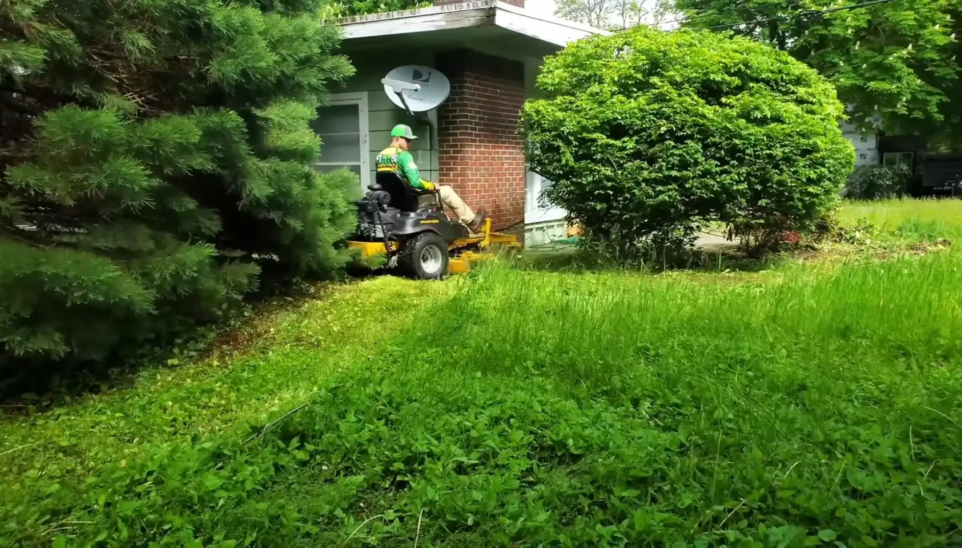 Waco lawn services trimming thick grass around bushes and trees with a ride-on mower